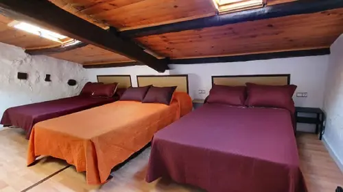 habitación-sol-casa-rural-lleida-cal-curpets-agramunt-lleida Bonita habitación de estilo rústico con tres camas dobles y un total de 6 plazas para huéspedes en la casa rural Cal Curpets.